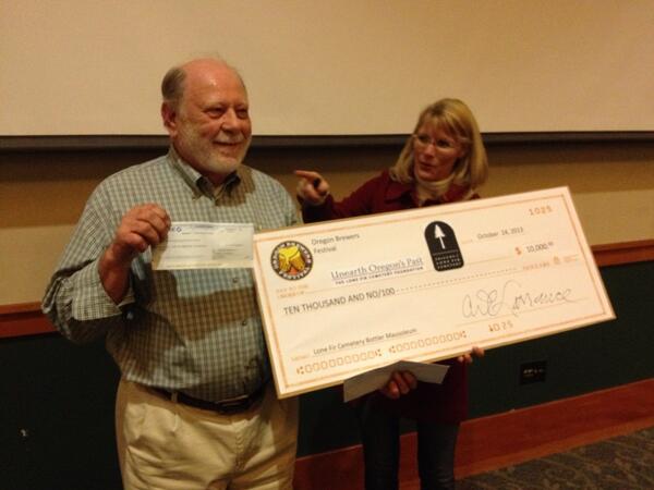 Art Larrance of OBF presents huge and tiny checks to Melissa McDonald of Portland Metro courtesy of Oregon Brewers Festival
