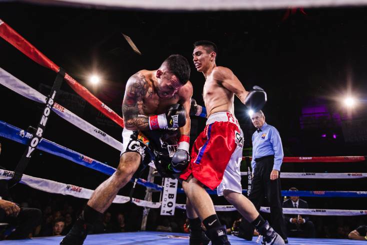 two prfessional boxers fighring in boxing ring