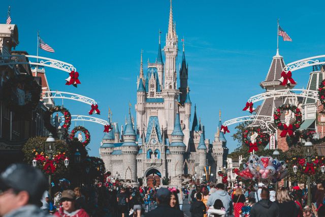 Cinderella Castle at Walt Disney World , with crowds of people on Main Street, U.S.A..