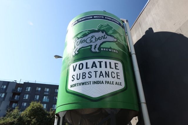 "Giant Von Ebert Brewing Volatile Substance Northwest India Pale Ale beer can silo outdoors against a clear sky"