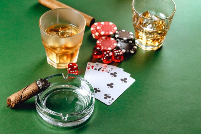 Poker setup with whiskey, cigar, dice, and chips, highlighting the social side of casino gaming
