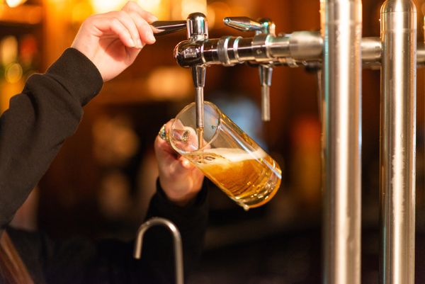 A beer lover is pouring beer from a bar draft