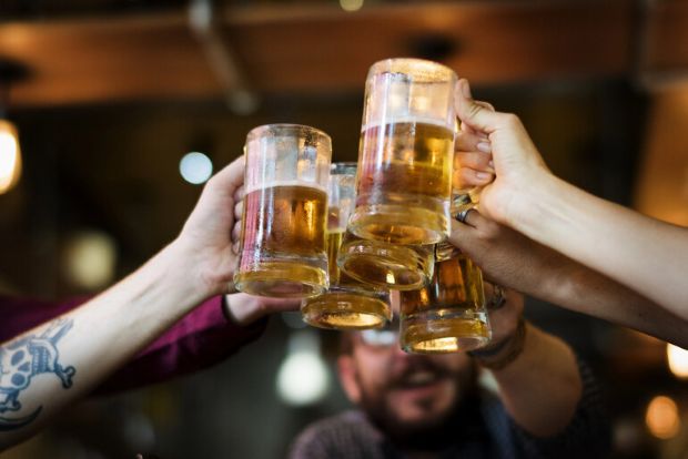 Friends clinking glasses of craft beer in a celebratory toast.