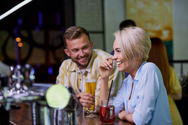 Smiling couple dating at a local brewery bar
