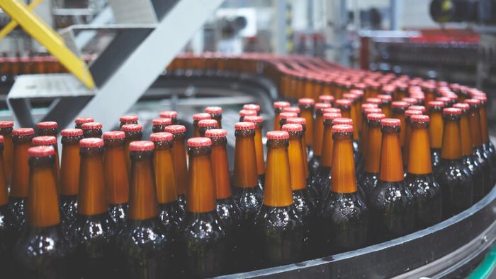 Declining U.S. craft beer production shown by rows of bottled beer on a brewery production line.