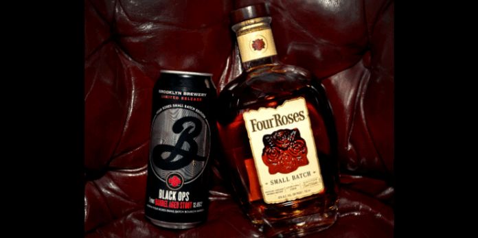 A can of Brooklyn Brewery Black Ops beer next to a bottle of Four Roses Small Batch bourbon on a red leather surface.