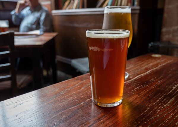 Pint glasses of craft beer on a wooden pub table