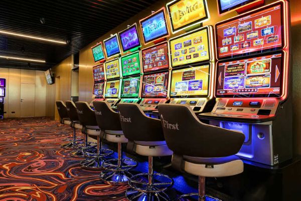 Colorful five-reel slot machines lined up in a modern casino gaming area