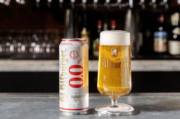 A can and a glass of Bitburger 0.0 alcohol-free beer are displayed on a bar counter