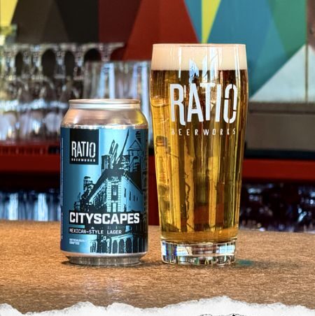 A can and a glass of Ratio Beerworks "Cityscapes" Mexican-Style Lager sit on a wooden bar top