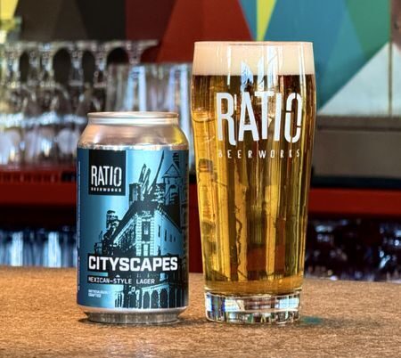 A can and a glass of Ratio Beerworks "Cityscapes" Mexican-Style Lager sit on a wooden bar top