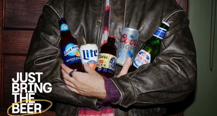 A person in a brown leather jacket holds an assortment of four different alcoholic beverages (bottles of Blue Moon, Coors Banquet, and Peroni Nastro Azzurro, and a can of Miller Lite). The text "JUST BRING THE BEER" is overlaid on the lower left.