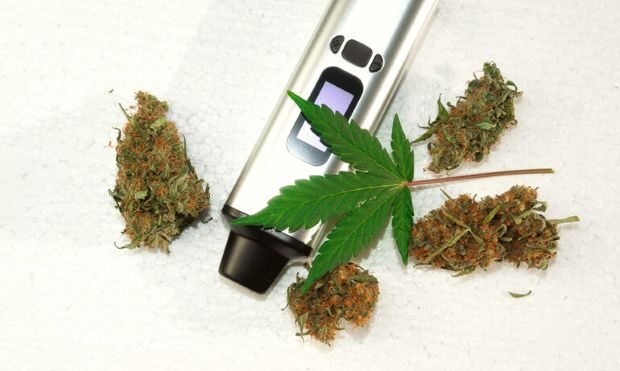 A herb vaporizer surrounded by dry leaves