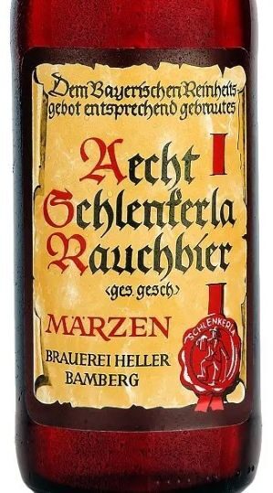 A close-up of a glass beer bottle with a parchment-style label featuring German text in a Gothic font, including the words "Aecht Schlenkerla Rauchbier" and "MARZEN", and a red wax seal logo