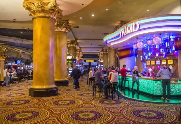Craft beer lounge inside a Las Vegas casino with patrons seated at a modern bar and gaming floor in the background.