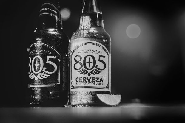 Black and white photo of two Firestone Walker 805 beer bottles on a surface next to a lime wedge