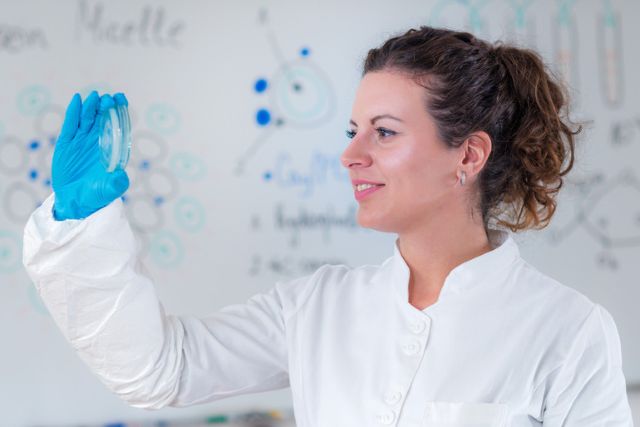 Scientist examining a petri dish for brewing research in a laboratory