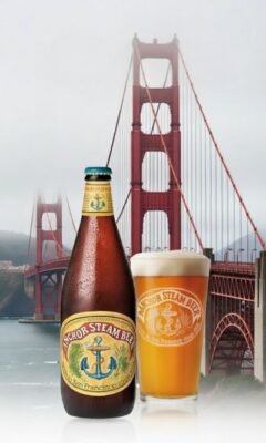A bottle and glass of Anchor Steam beer with the Golden Gate Bridge in the background.