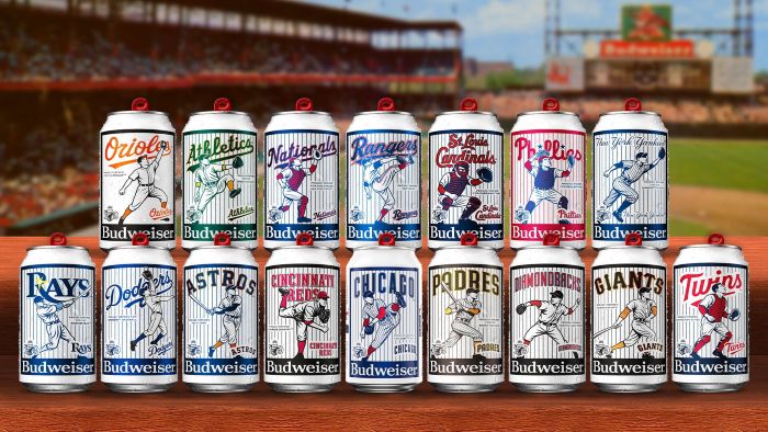 Two rows of limited-edition Budweiser beer cans featuring various Major League Baseball team logos and vintage-style player illustrations, set against a blurred baseball stadium background.