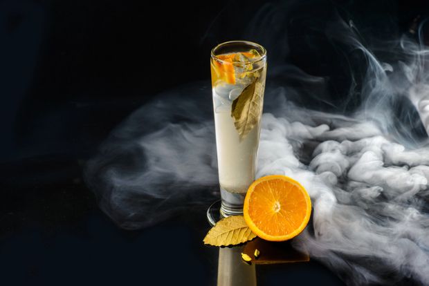 Citrus craft drink with orange garnish and vapour smoke, the evolution of flavour culture from craft beer trends to modern vaping experiences.
