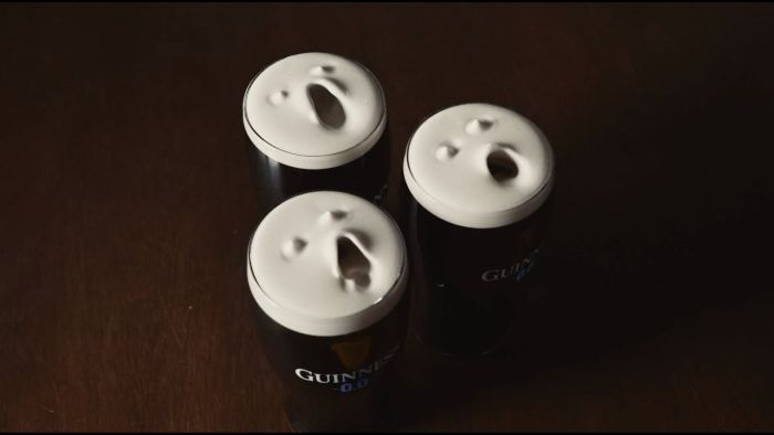 Three pints of Guinness stout viewed from above, with the white foam on top manipulated to look like three screaming faces.