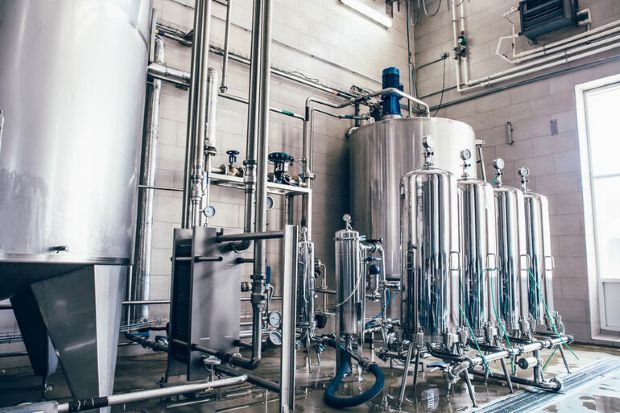 Expanding craft brewery brewhouse with stainless steel fermentation tanks and an organized production layout for efficient beer brewing.