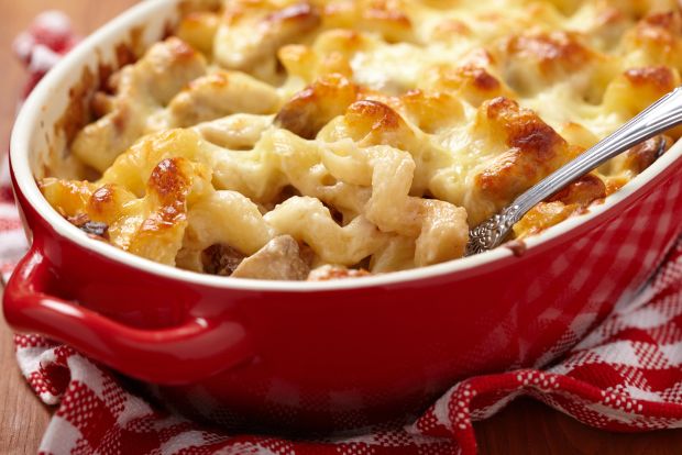 Baked macaroni and cheese with a golden-brown crust in a red ceramic dish.