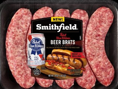 A 19-ounce package of raw Smithfield Pabst Blue Ribbon Beer Bratwurst in a black tray, featuring a label with the PBR logo and a picture of a grilled bratwurst in a bun. 