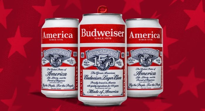 Three Budweiser beer cans with patriotic "America" branding, featuring red, white, and blue labels with stars and eagle motifs against a red background with faint stars.