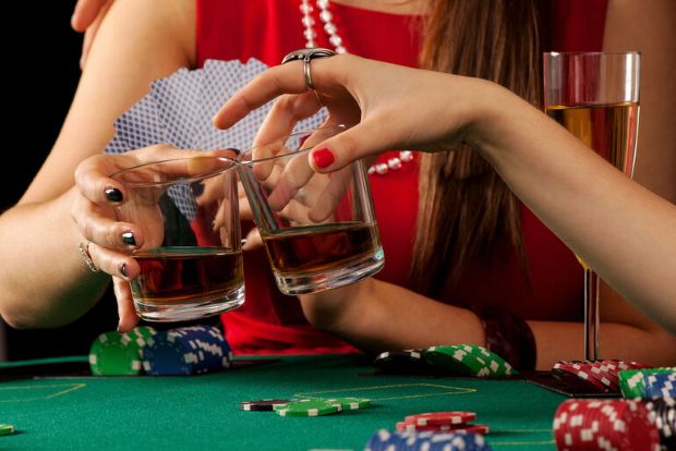  Friends enjoying drinks and casino games at a poker table, reflecting the growing appeal of slots among online beer-loving casino users.
