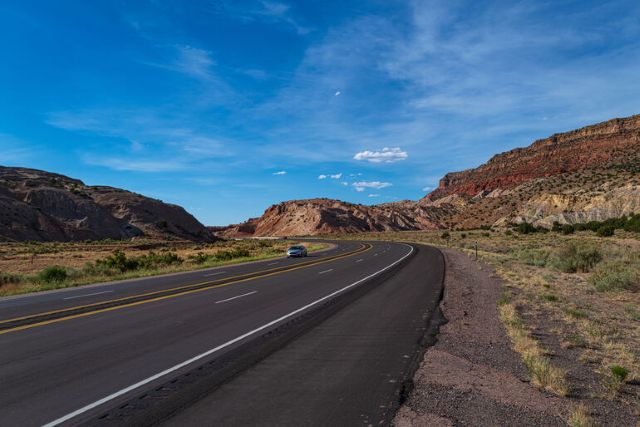 Scenic open road stretching through rural American landscape, representing a craft brewery road trip with views of countryside and distant mountains.