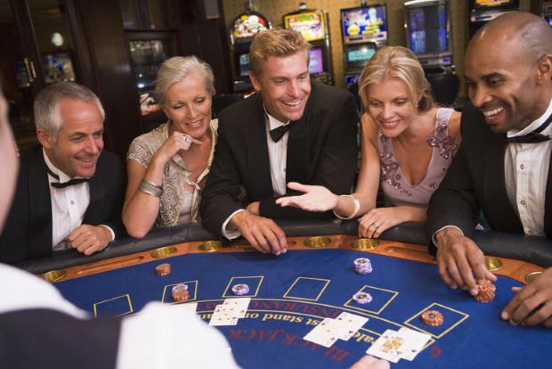 Elegant casino guests at a blackjack table during a busy game night, showing a lively casino bar atmosphere.