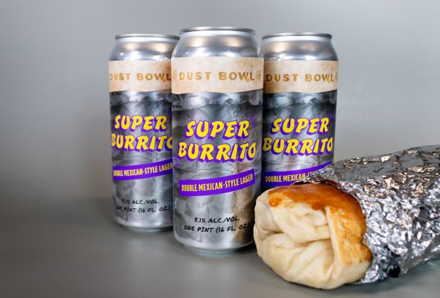 Three tall beer cans labeled "Dust Bowl Super Burrito Double Mexican-Style Lager" stand behind a foil-wrapped burrito.