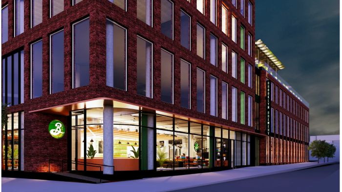 A digital rendering of the multi-story brick exterior of the Brooklyn Brewery building at night, showing large ground-floor windows and an illuminated entrance.