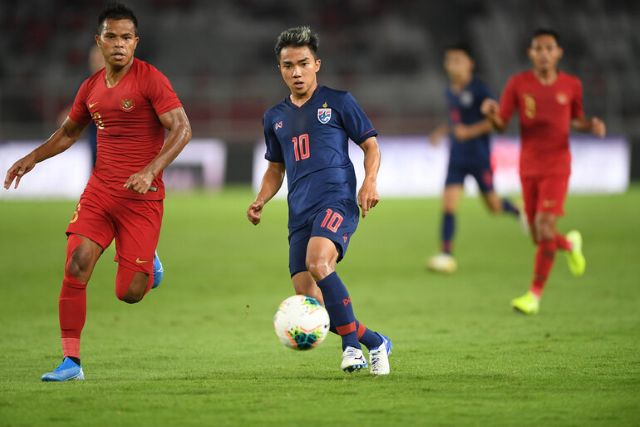 Malaysia and Thailand players in action during an international football match, showcasing Malaysian football on the regional stage.