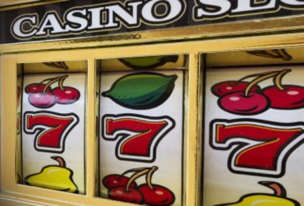 Slot machine reels with lucky red sevens and fruit symbols, representing the significance of the number seven in gambling.