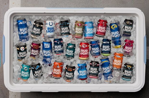 An overhead shot of an ice-filled white cooler packed with NFL-branded Bud Light cans.