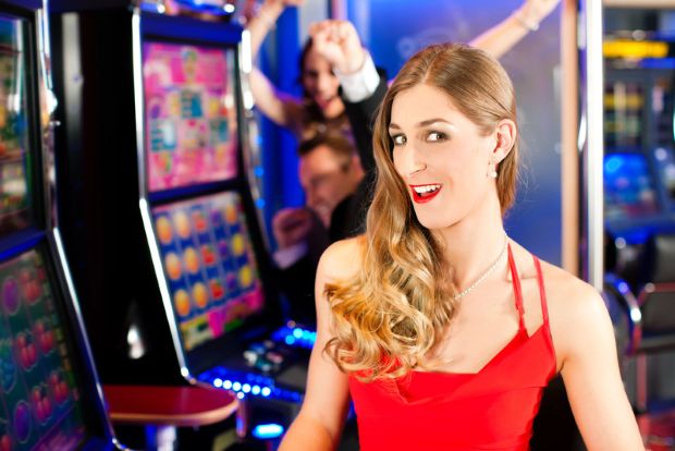 A beer lover in front of a slot machine in a casino. 