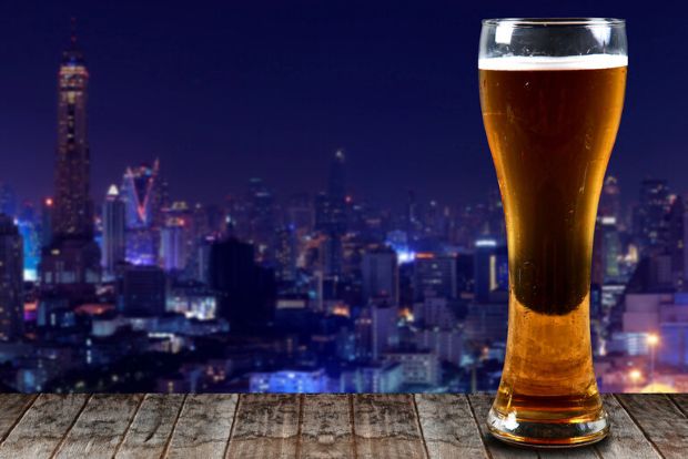 Glass of beer overlooking a city skyline while exploring which country has the best beer.