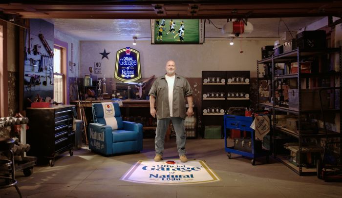 Natural Light Ultimate Garage with branded recliner, NattyTron and Natural Light floor logo.