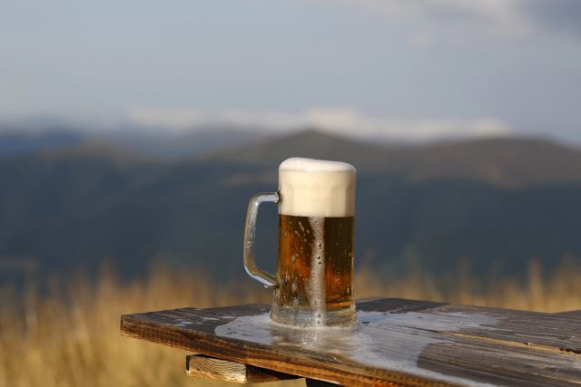A beer mug filled with beer in a high-altitude location.
