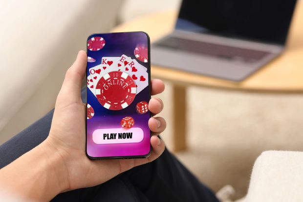A Man playing online poker on a mobile phone..