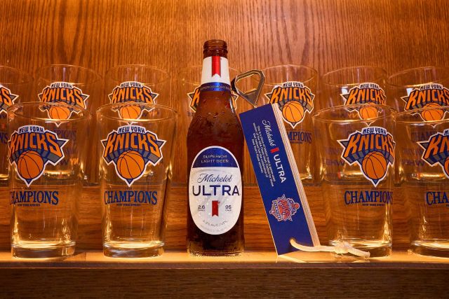 Michelob ULTRA beer bottle and Knicks championship hardwood bottle opener displayed with New York Knicks 2026 championship glasses.
