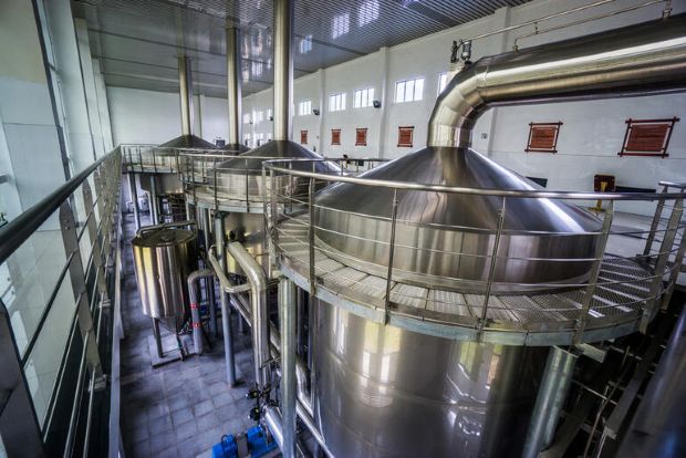 Stainless steel brewing tanks inside a brewery for pilot batch testing and recipe development.
